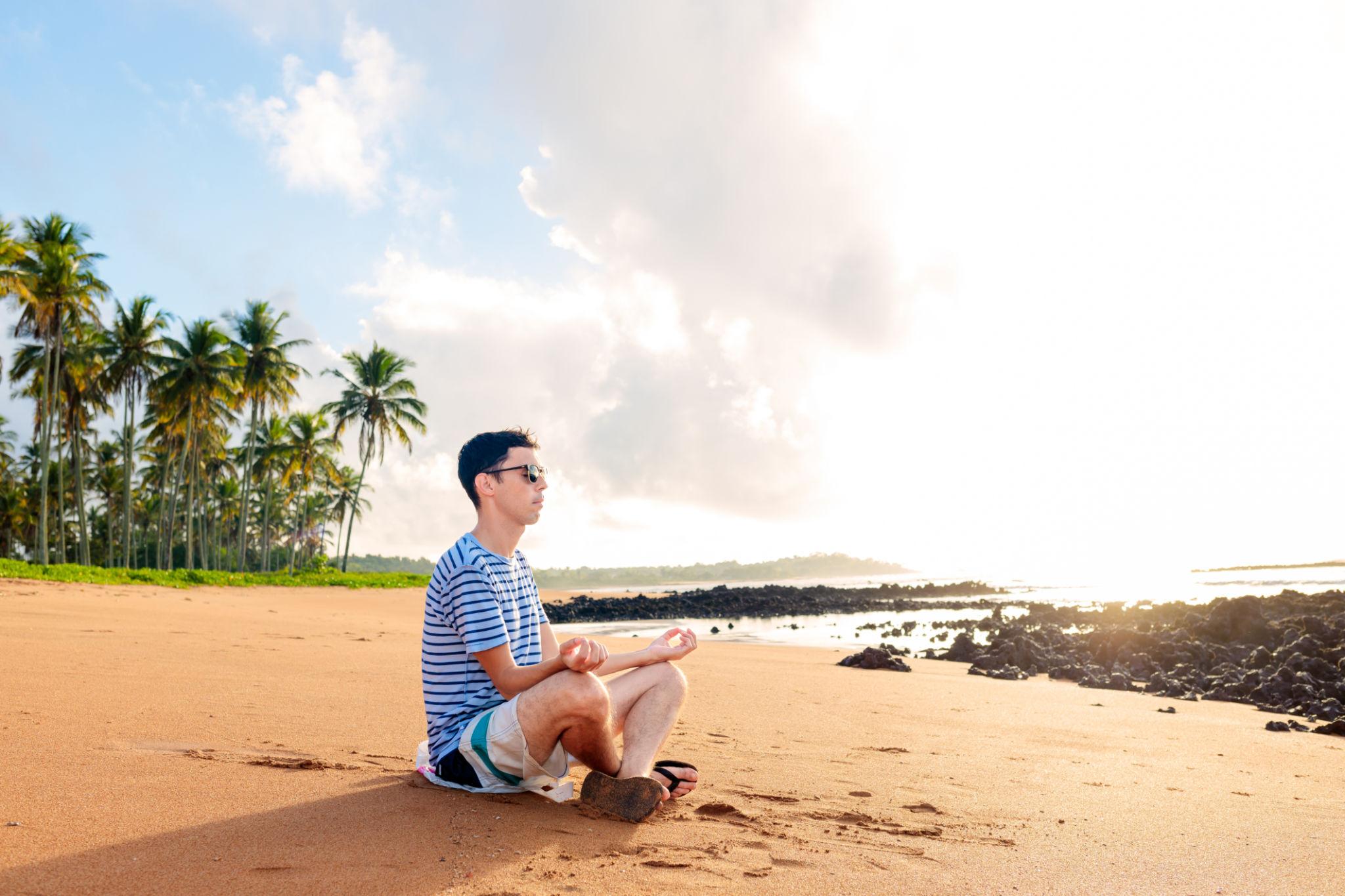 Tranquility and Stress Relief: Person Relaxing and Meditating on the Beach
