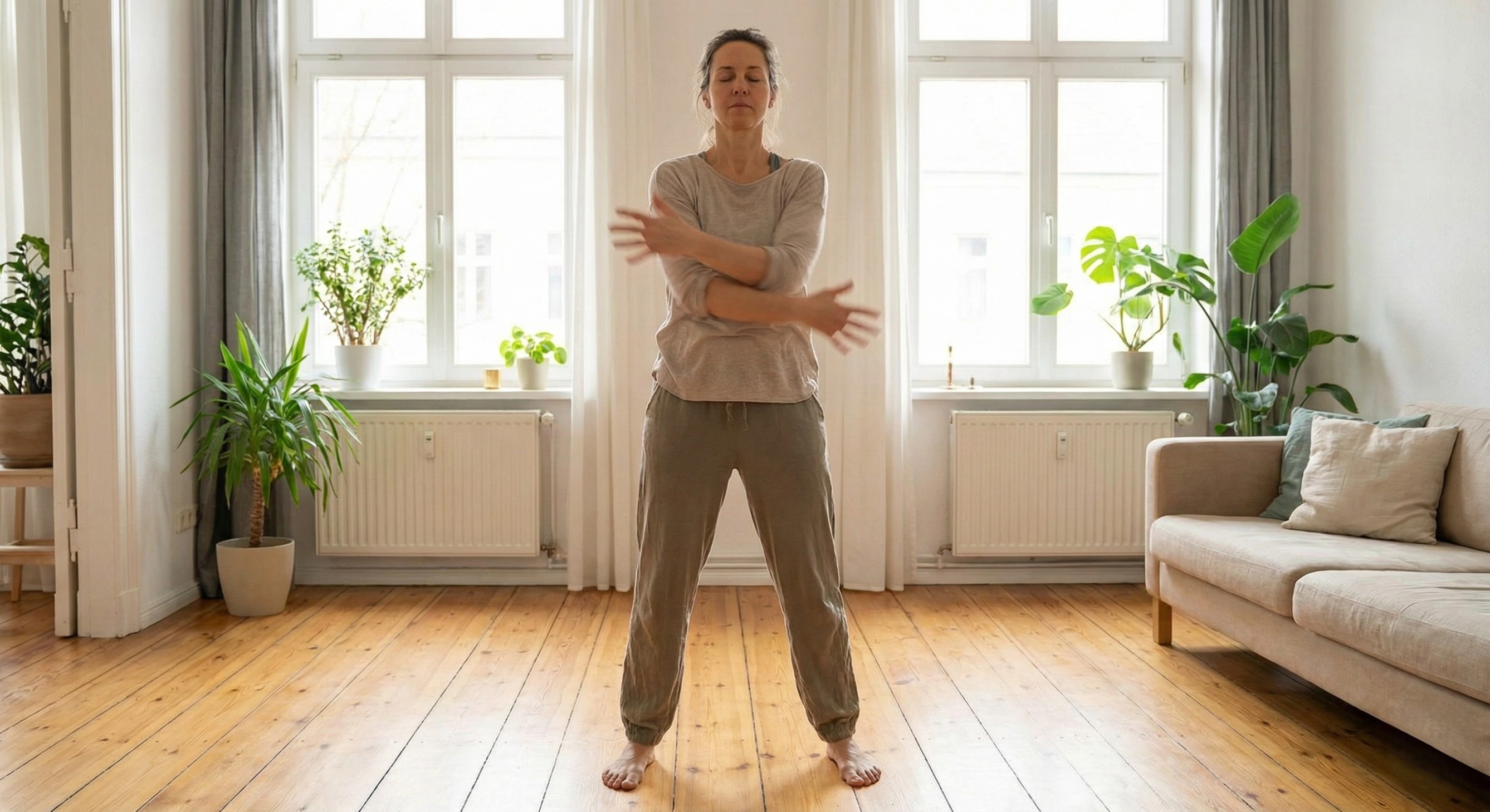Woman practicing somatic shaking exercises in a living room to release physical tension and regulate the nervous system.