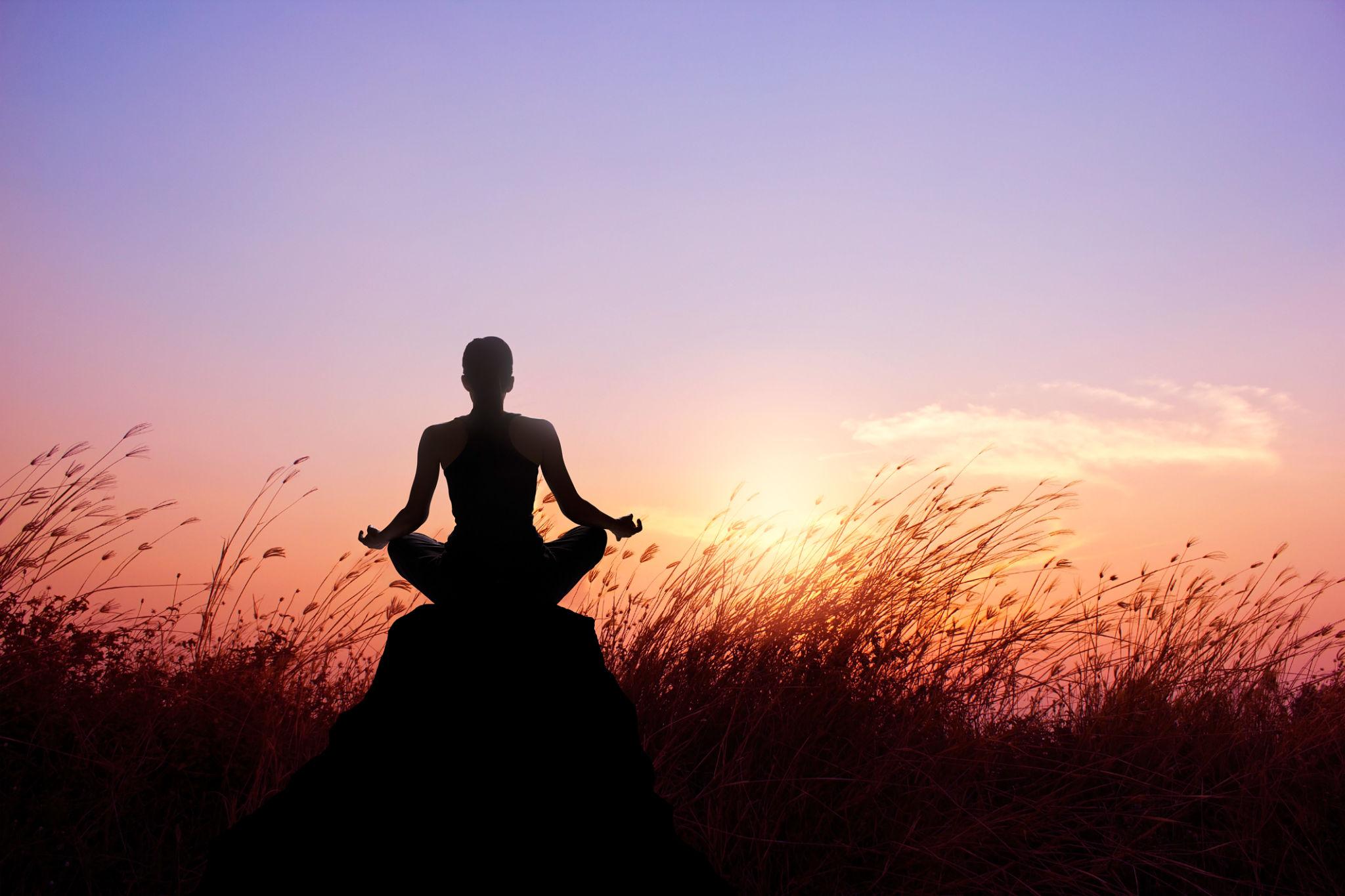 Woman yoga and meditation silhouette on nature sunset background