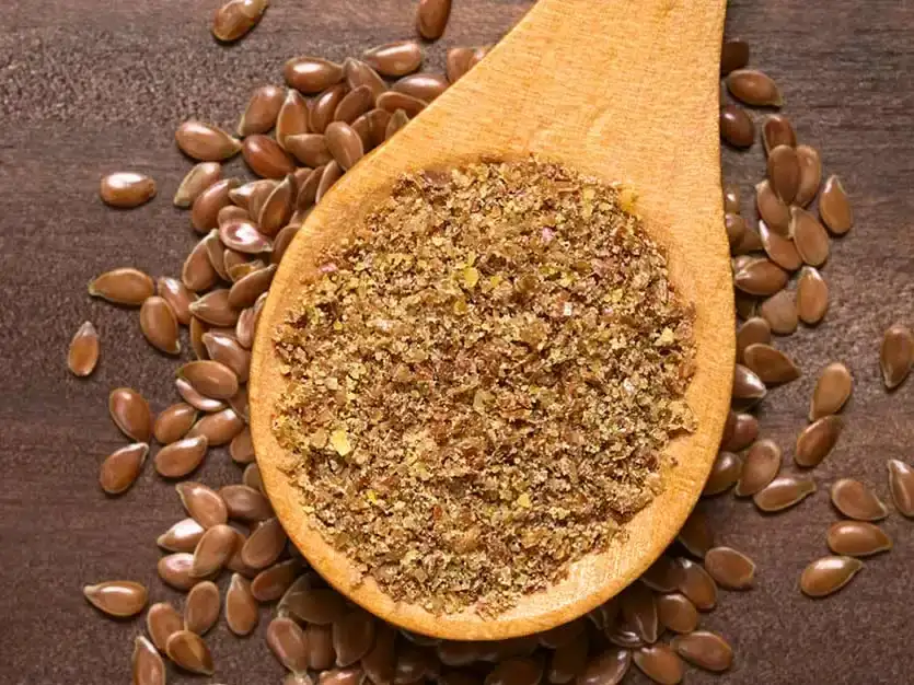 Ground-and-whole-flaxseeds-on-a-wooden-table