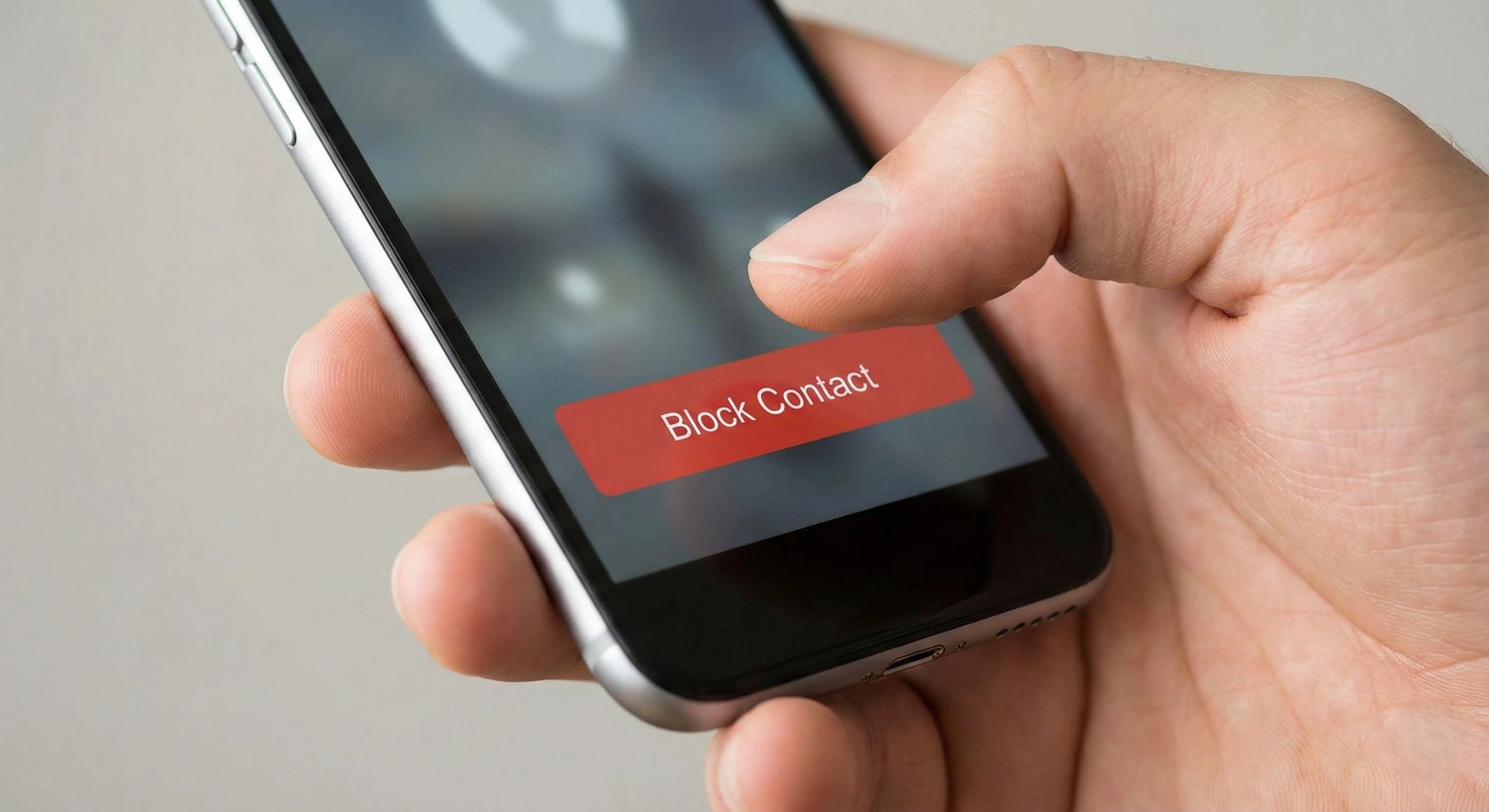 A hand holding a smartphone and pressing the 