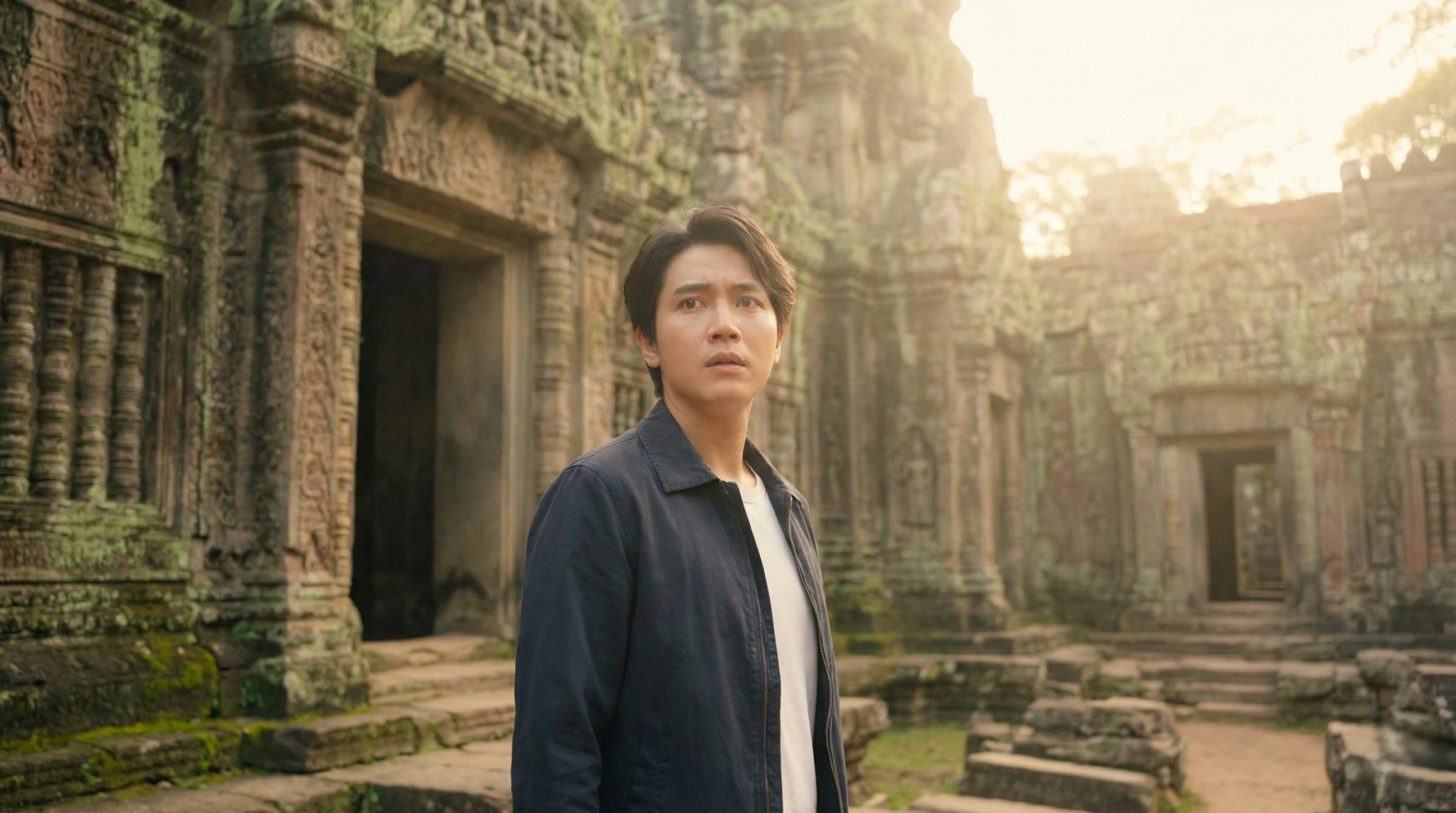 A man looking with a sense of deep recognition and déjà vu while standing in front of ancient, moss-covered stone ruins, illustrating the experience of recalling past life memories in a familiar location.