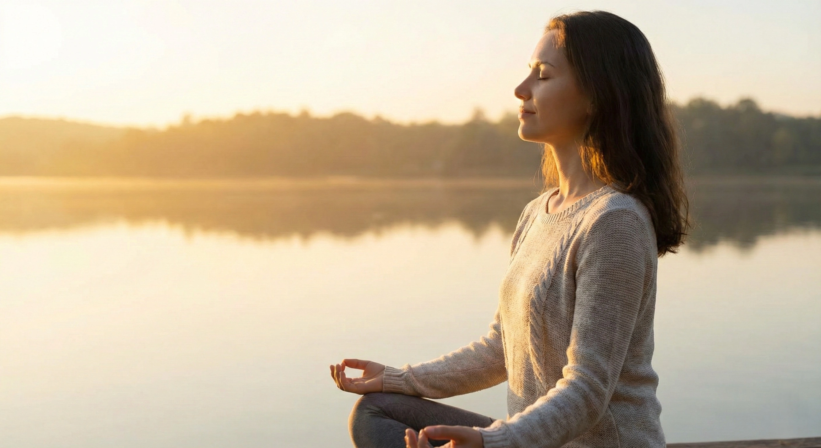 A person finding inner peace and letting go of worries in a serene natural setting at sunrise.